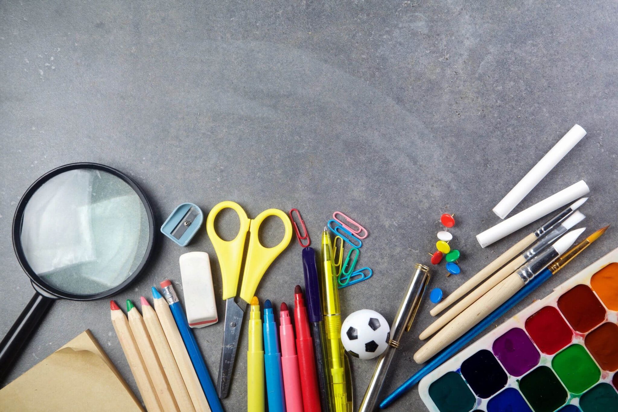 A table topped with lots of school supplies.