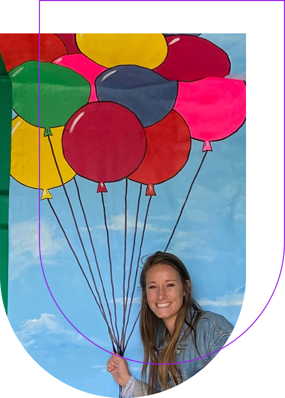 A woman standing in front of balloons on a sky background.