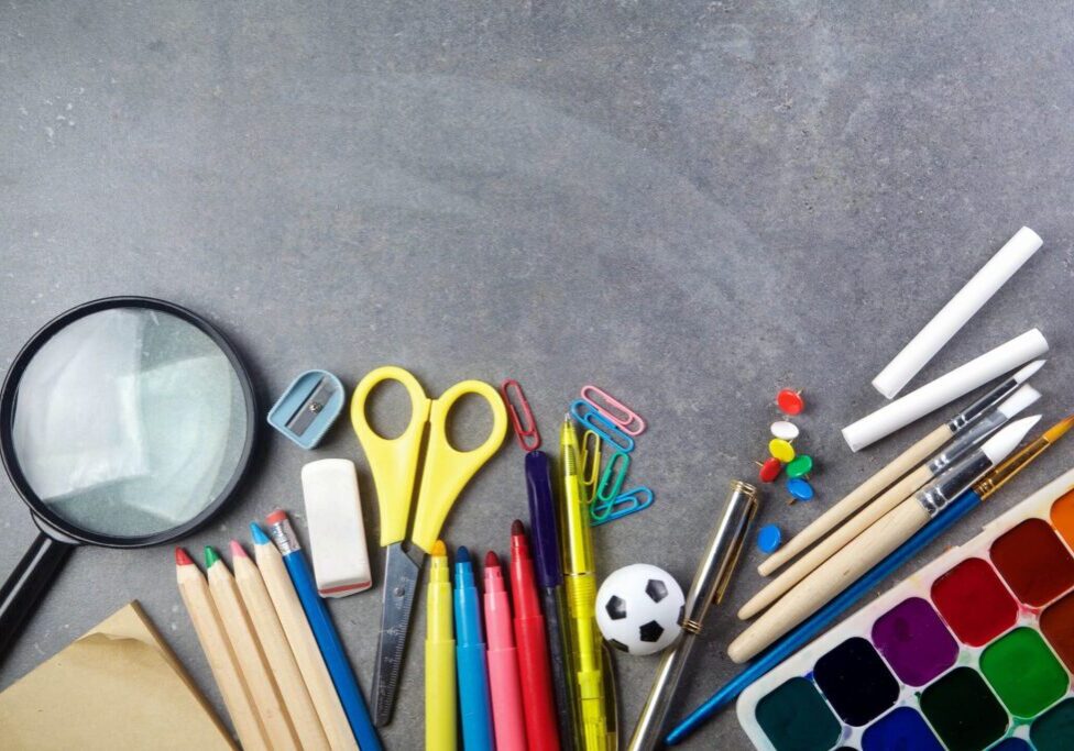 A table topped with lots of school supplies.